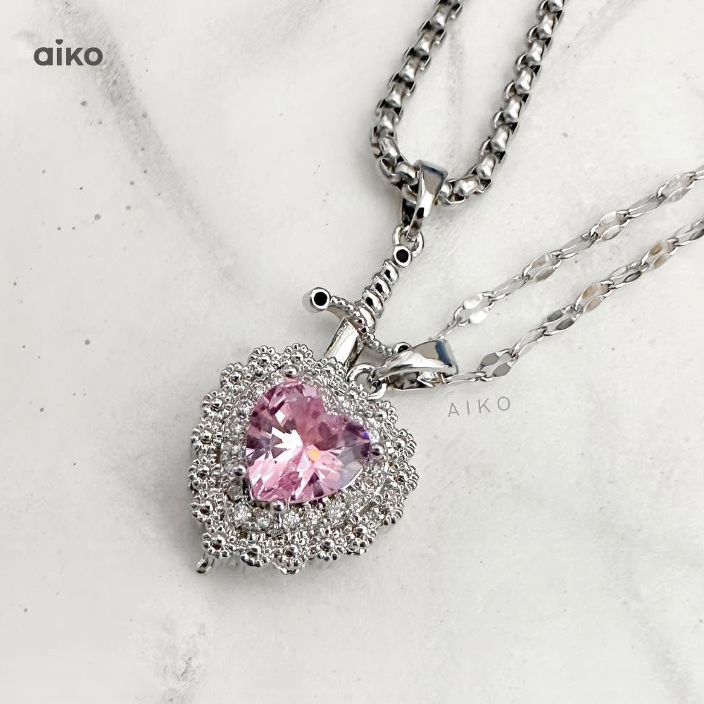 Collar de acero con dije de corazón sobre fondo claro